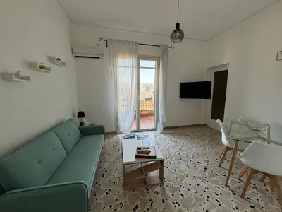 a living room with a green couch and a table at Licia's home in Palermo