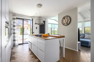 a white kitchen with a clock on the wall at Luxury villa Taravilla with pool in Altavilla Milicia