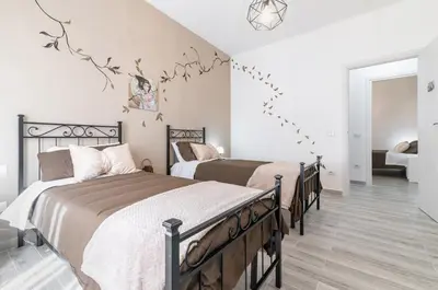 two beds in a bedroom with white walls at GuestHost - Palermo Charming Flat with Terraces x6 in Palermo