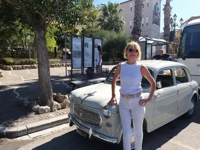 a woman standing in front of a white car at la Maison 
