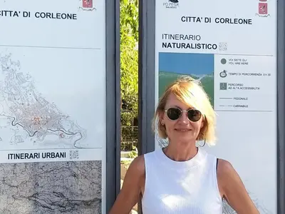 a woman wearing sunglasses standing in front of a sign at la Maison 