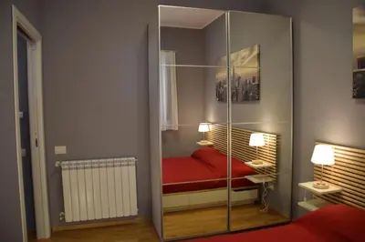 a room with a glass partition with a red bed at Palermo Holidays in Mondello