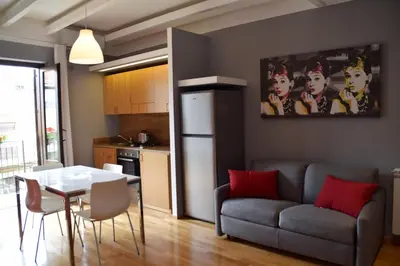 a kitchen and a living room with a table and a couch at Palermo Holidays in Mondello