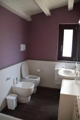 a bathroom with a toilet and two sinks and a window at Palermo Holidays in Mondello