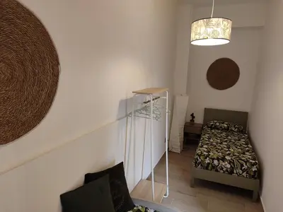 a small room with a bed and a stair case at L'Arco Verde San Nicola l'Arena in Trabia