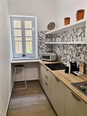 a kitchen with white cabinets and a sink and a window at L'Arco Verde San Nicola l'Arena in Trabia