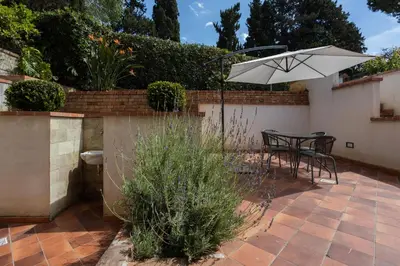 a patio with a table and an umbrella at Casa Ibiscus in Mondello