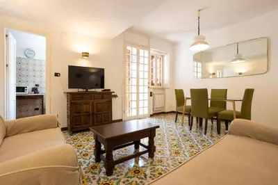 a living room with a tv and a table and chairs at Casa Ibiscus in Mondello