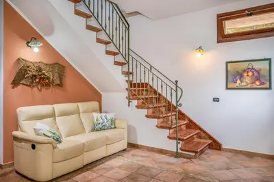 a living room with a couch and stairs at Villa Miceli con piscina privata in Scopello