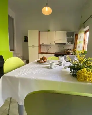 a table in a kitchen with a white table cloth at Appartamento Casa Trento in Castellammare del Golfo