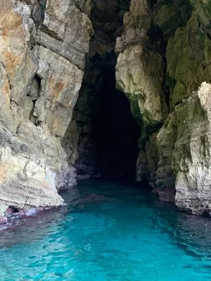 a cave with blue water in front of a cliff at Appartamento Casa Trento in Castellammare del Golfo