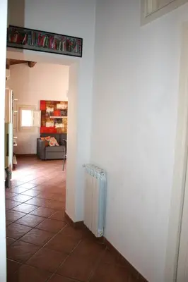 a hallway with a room with a couch and a radiator at Casa Bellini in Palermo