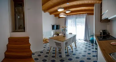 a kitchen and dining room with a table and chairs at Casa Rosa Castellammare del Golfo in Castellammare del Golfo