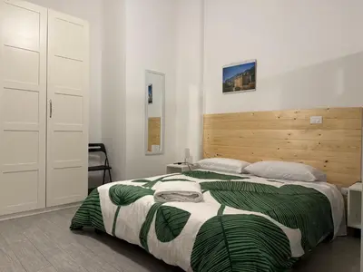 a bedroom with a large bed with a wooden headboard at A CASA DI IDA in Palermo