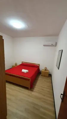 a bedroom with a red bed in a room at Villa Chifeci Scopello - Appartamento Rosso in Scopello