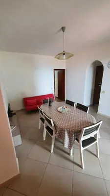 a living room with a table and a red couch at Villa Chifeci Scopello - Appartamento Rosso in Scopello