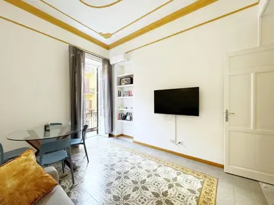 a living room with a table and a tv on a wall at Solemar Sicilia - Casa Markiz in Palermo