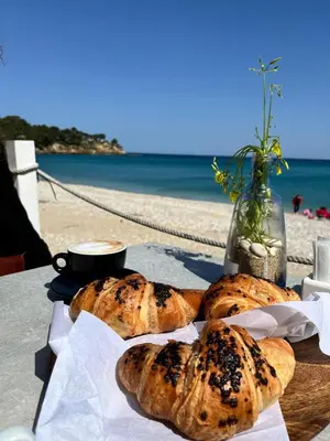a table with three loaves of bread on a table near the beach at Villa Chifeci Scopello - Appartamento La Zàgara in Scopello