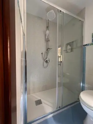 a bathroom with a glass shower with a toilet at L'Aurora in Porticello