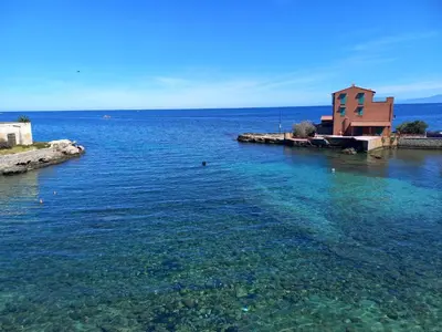 a large body of water with a building in it at L'Aurora in Porticello