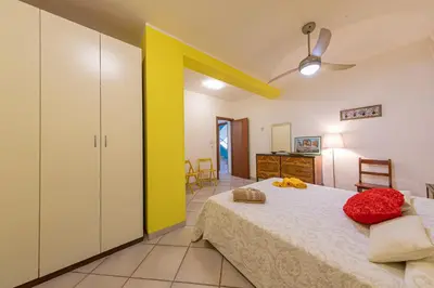 a bedroom with a bed and a yellow wall at Villa Le Terrazze in Cefalù