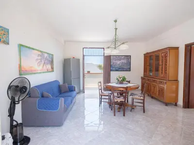 a living room with a blue couch and a table at [Baia di Guidaloca] Villino Scopello Free Parking in Scopello