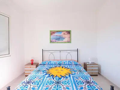 a bedroom with a bed with a colorful bedspread at [Baia di Guidaloca] Villino Scopello Free Parking in Scopello