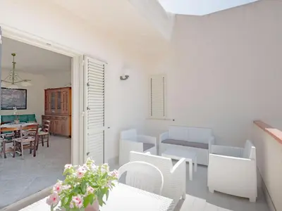 a living room with white furniture and a table at [Baia di Guidaloca] Villino Scopello Free Parking in Scopello