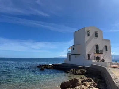 a building on the shore of the ocean at Casetta Bianca Sant'Elia in Porticello