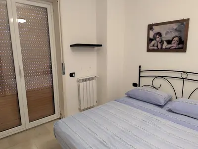 a bedroom with a bed and a sliding glass door at Rosalba apartments - cheap and characteristic in Palermo