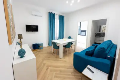 a living room with a blue couch and a table at Casa Gaia in Terrasini