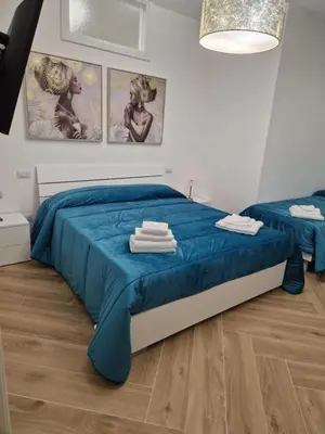 a bedroom with a blue bed with towels on it at Casa Gaia in Terrasini