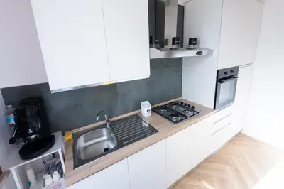 a white kitchen with a sink and a stove at Casa Gaia in Terrasini