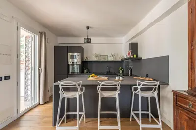 a kitchen with a gray island with bar stools at Villa Giovanna con Piscina by Wonderful Italy in Castellammare del Golfo