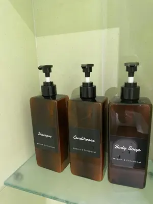 three bottles of soap sitting on a shelf at Baaria house in Bagheria