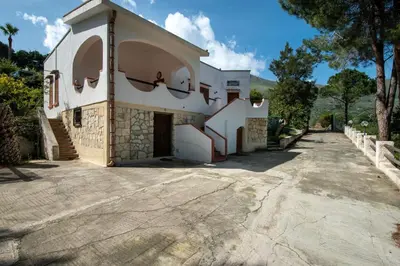 a large white building with a driveway at Villa Acquamarina - 300 meters from the sea in Scopello