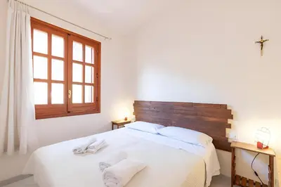 a bedroom with a white bed with two towels on it at Casa Vacanze Maria in San Vito lo Capo