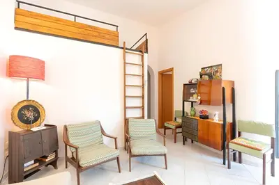 a living room with chairs and a tv and a shelf at Casa Vacanze Maria in San Vito lo Capo