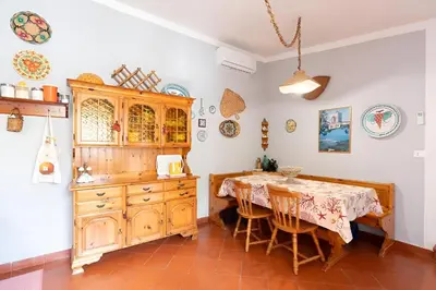 a dining room with a table and a wooden cabinet at Casa Vacanze Maria in San Vito lo Capo