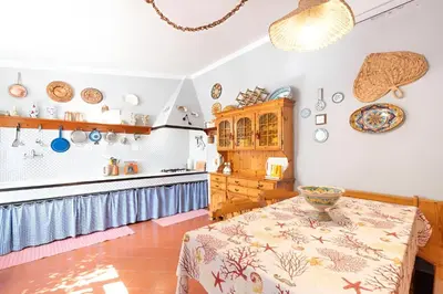 a kitchen with a table and a counter top at Casa Vacanze Maria in San Vito lo Capo
