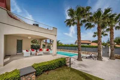 a backyard with a swimming pool and palm trees at Villa Jacqueline con piscina privata 8 posti letto in Scopello
