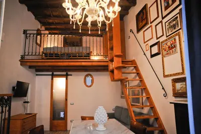 a living room with a staircase and a chandelier at 4 Canti Central Loft & Ground floor in Palermo
