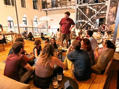 a group of people sitting on the floor listening to a speaker at Ostello Bello Palermo in Palermo