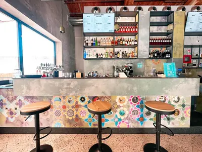 a restaurant with two stools in front of a counter at Ostello Bello Palermo in Palermo