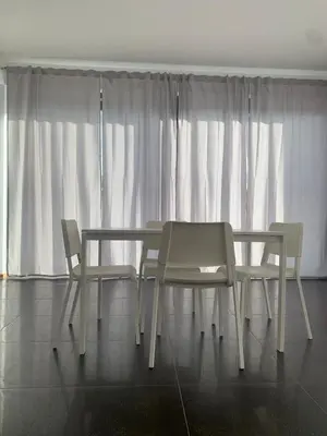 a white table and two chairs and a window at Villa Rubino in Isola delle Femmine