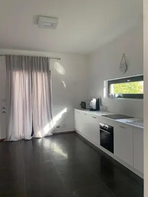 a kitchen with white cabinets and a window and a stove at Villa Rubino in Isola delle Femmine