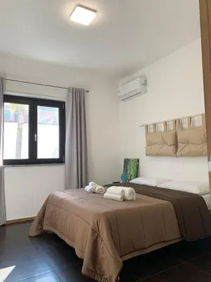 a bedroom with a large bed with towels on it at Villa Rubino in Isola delle Femmine