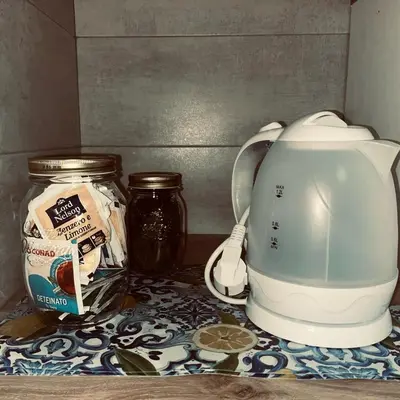 a tea kettle and a jar of honey on a counter at Silvia's House in Castellammare del Golfo