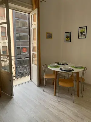 a dining room with a table and chairs and a window at A casa di Elvira in Palermo
