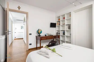 a white bedroom with a bed and a desk at Verosicily Villa Barcellona in Terrasini